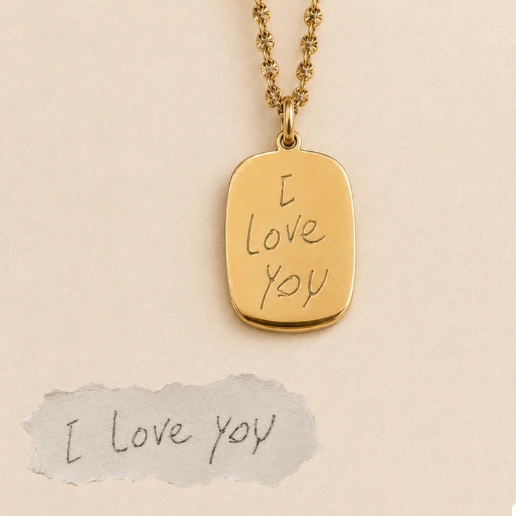 Gold medallion necklace engraved with handwritten 'I love you', beside the original handwriting