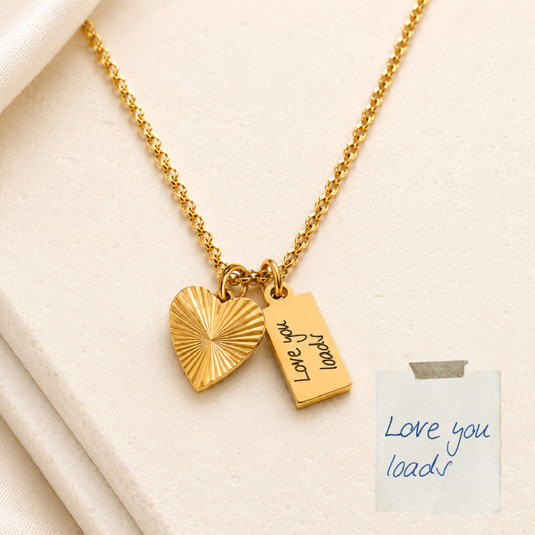 Gold necklace with heart-shaped pendant and engraved tag