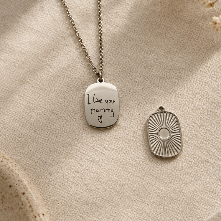 Silver medallion necklace engraved with handwritten 'I love you mummy' next to the sunburst side