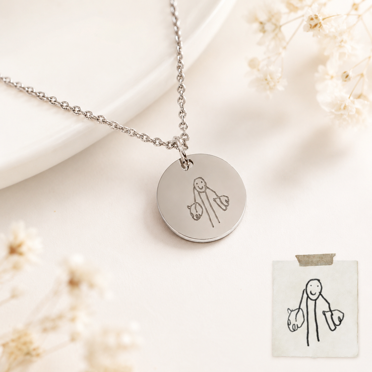 Silver necklace with a round pendant featuring a stick figure design