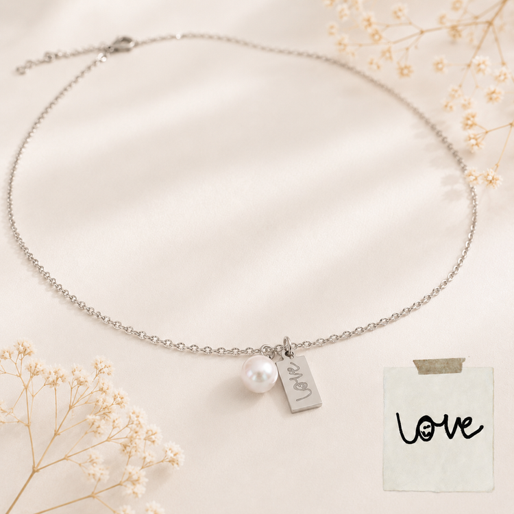 Custom Necklace with a pearl charm and 'love' tag on a light background