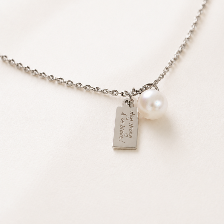 Necklace with a silver tag and pearl on a white background