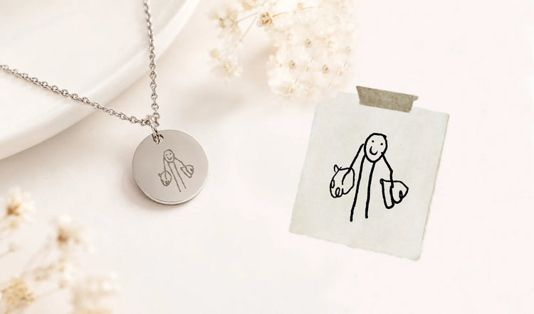 Close-up of engraved kid's drawing engraved on round necklace pendant
