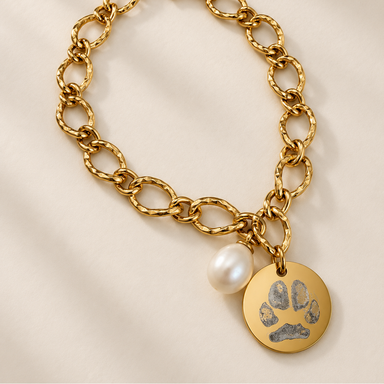 Gold pawprint chain bracelet with a disc charm engraved with a pet's paw print and a natural pearl